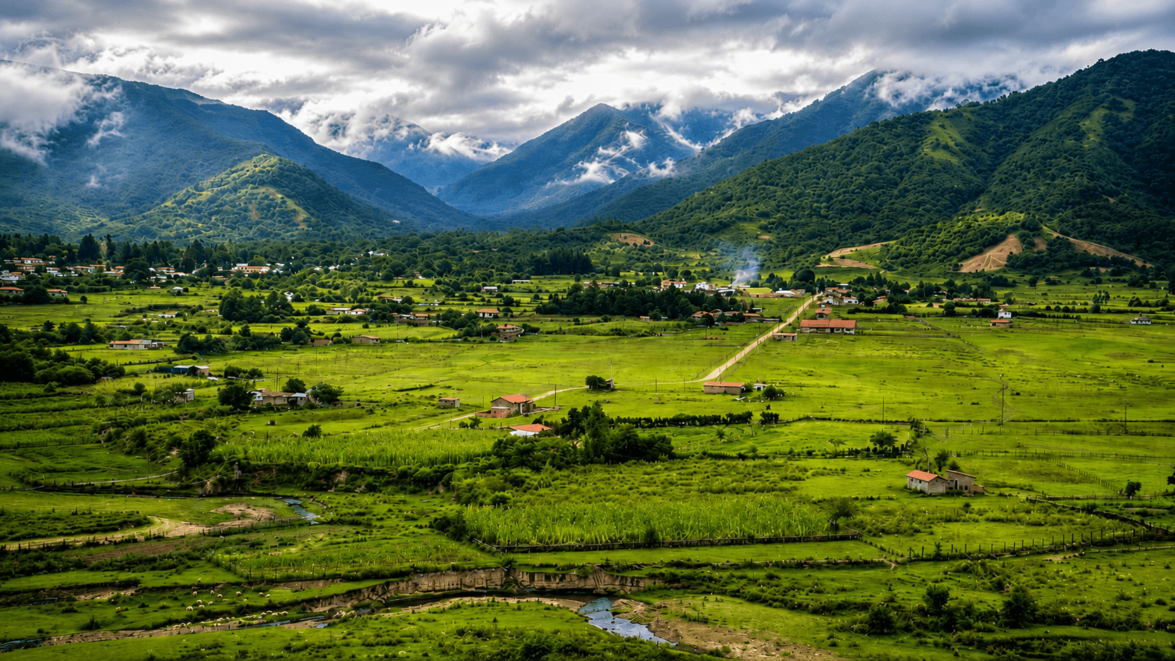Valle verde de Los Toldos rodeado de montañas con nubes